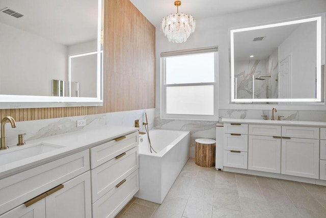 138 NW Magnolia Lakes Blvd, Port Saint Lucie, FL 34986 - full bathroom featuring a marble finish shower, two vanities, a chandelier, a garden tub, and tile patterned floors