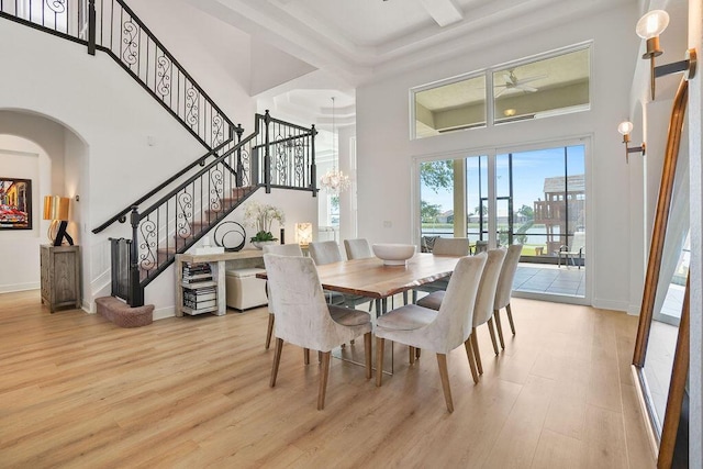 138 NW Magnolia Lakes Blvd, Port Saint Lucie, FL 34986 - dining area with a high ceiling, light wood-type flooring, stairway, ceiling fan, and baseboards