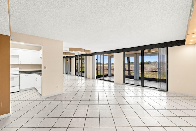 unfurnished room with a textured ceiling and light tile patterned flooring