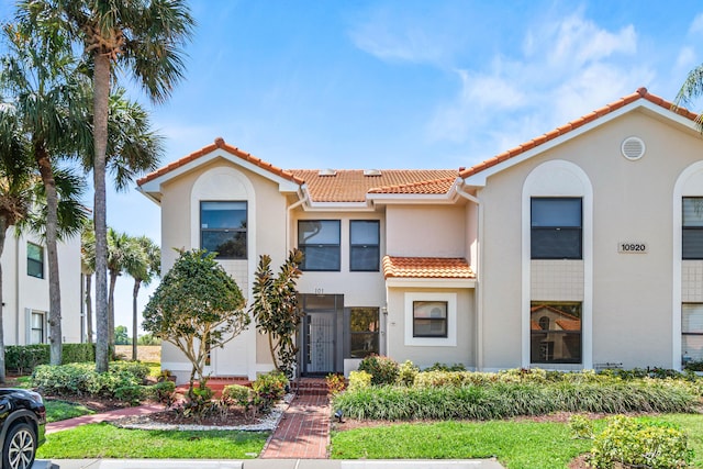 view of property featuring a tile roof and stucco siding