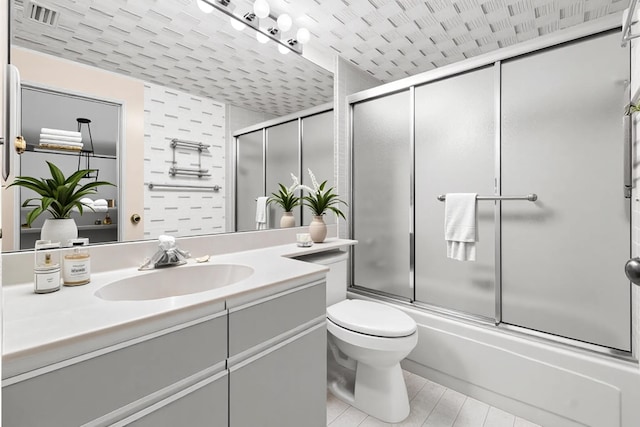 bathroom featuring enclosed tub / shower combo, vanity, and toilet