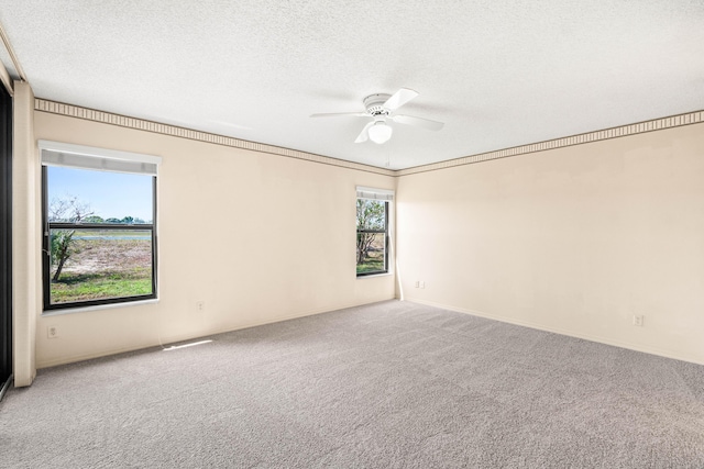 empty room featuring ceiling fan, carpet flooring, a textured ceiling, and baseboards