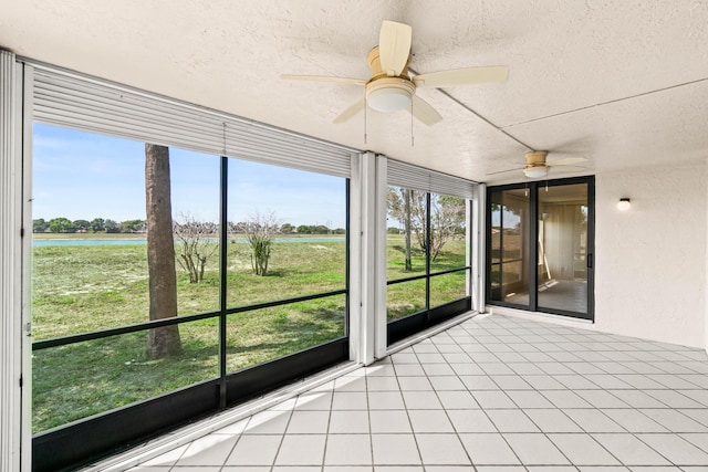 unfurnished sunroom with a water view, ceiling fan, and healthy amount of natural light
