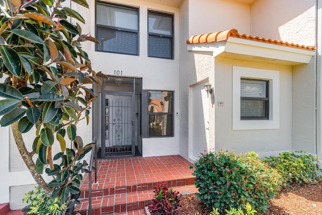 property entrance featuring stucco siding and a tile roof
