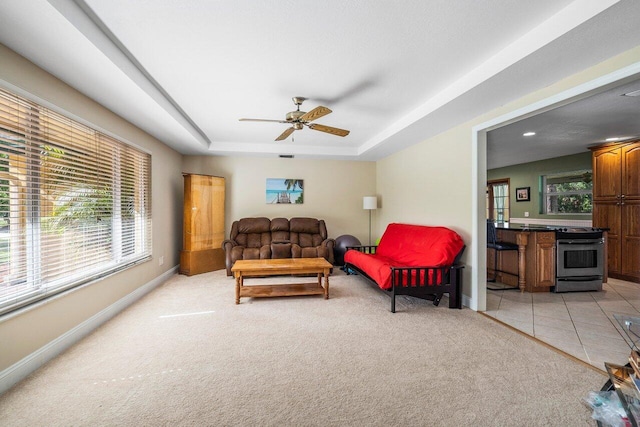 4901 129th Ave N, The Acreage, FL 33411 - living area featuring light colored carpet, baseboards, ceiling fan, and a raised ceiling