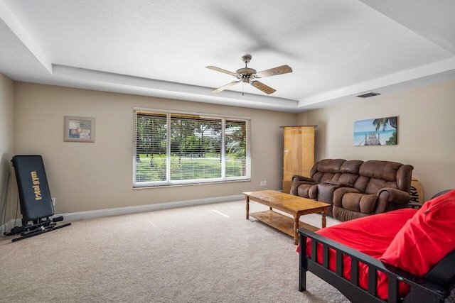 4901 129th Ave N, The Acreage, FL 33411 - carpeted living room with ceiling fan, baseboards, and a tray ceiling