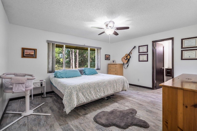 4901 129th Ave N, The Acreage, FL 33411 - bedroom with wood finished floors, a textured ceiling, baseboards, and a ceiling fan