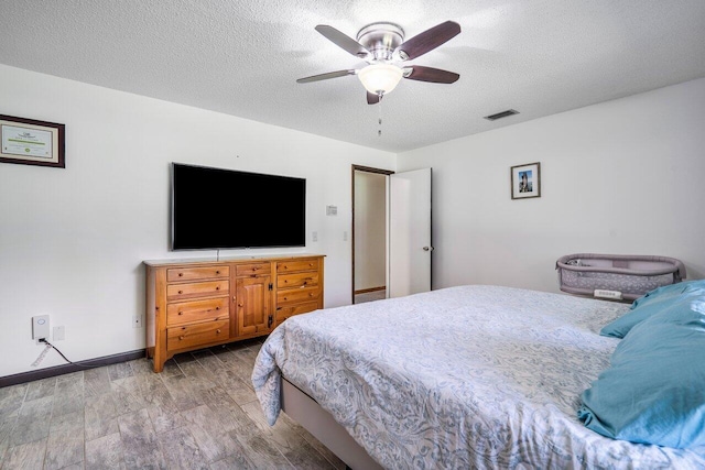 4901 129th Ave N, The Acreage, FL 33411 - bedroom with light wood-type flooring, a textured ceiling, a ceiling fan, and baseboards