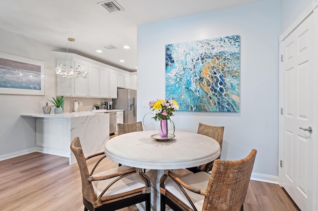 1310 S Jeaga Dr, Jupiter, FL 33458 - dining space featuring light wood-style flooring, recessed lighting, baseboards, and a chandelier