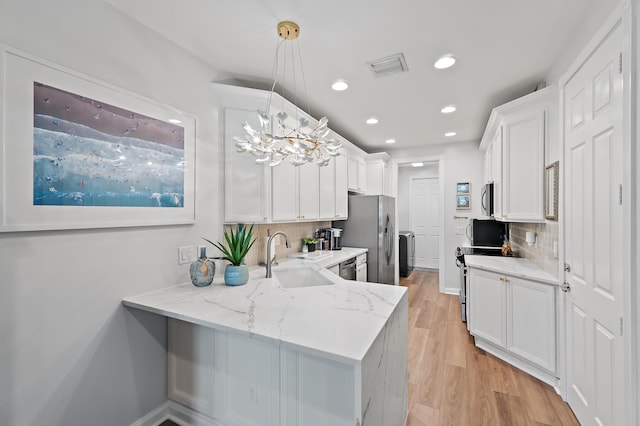 1310 S Jeaga Dr, Jupiter, FL 33458 - kitchen with a sink, recessed lighting, white cabinets, stainless steel appliances, and tasteful backsplash
