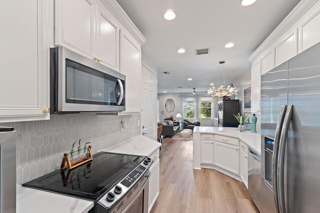 1310 S Jeaga Dr, Jupiter, FL 33458 - kitchen featuring appliances with stainless steel finishes, open floor plan, recessed lighting, light wood-style flooring, and white cabinets