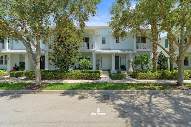 1310 S Jeaga Dr, Jupiter, FL 33458 - view of front of property featuring a balcony, a standing seam roof, metal roof, and covered porch