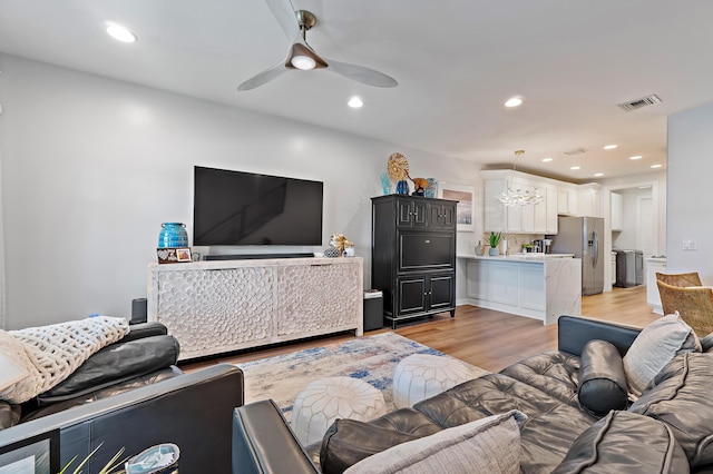 1310 S Jeaga Dr, Jupiter, FL 33458 - living room with light wood-style flooring, ceiling fan, recessed lighting, and a chandelier