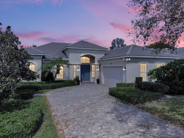 2068 Wightman Dr, Wellington, FL 33414 - view of front of house with a tile roof, a garage, stucco siding, and decorative driveway