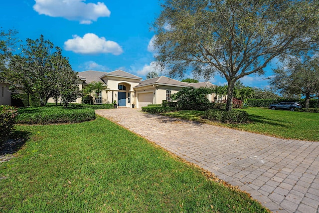 2068 Wightman Dr, Wellington, FL 33414 - mediterranean / spanish house with decorative driveway, a garage, stucco siding, and a front lawn