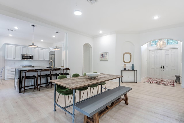 2068 Wightman Dr, Wellington, FL 33414 - dining space with arched walkways, light wood finished floors, crown molding, recessed lighting, and baseboards
