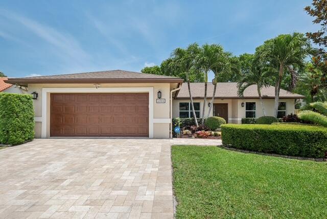 6085 Elmwood Dr, Boca Raton, FL 33433 - view of front of home featuring decorative driveway, stucco siding, a garage, and a front yard