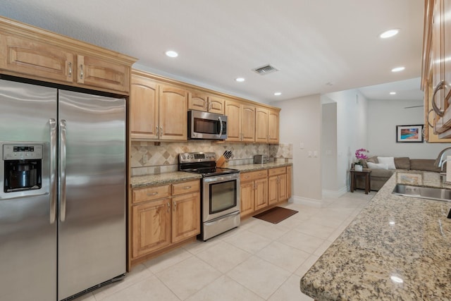 6085 Elmwood Dr, Boca Raton, FL 33433 - kitchen featuring stainless steel appliances, a sink, decorative backsplash, light stone counters, and light tile patterned floors