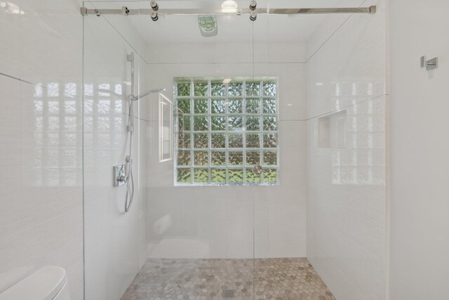 6085 Elmwood Dr, Boca Raton, FL 33433 - bathroom featuring toilet, tiled shower, and healthy amount of natural light