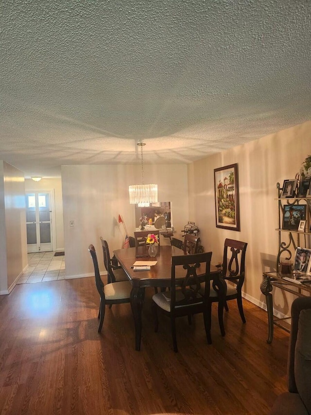 5794 Moss Ct Unit 7, Fort Pierce, FL 34982 - dining room featuring a textured ceiling, a chandelier, baseboards, and wood finished floors