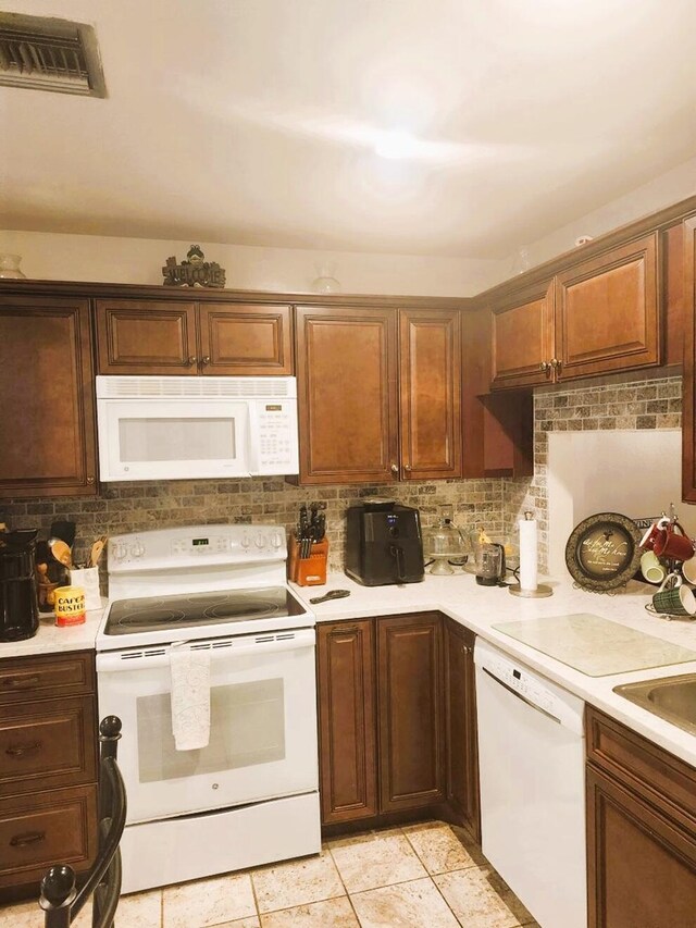 5794 Moss Ct Unit 7, Fort Pierce, FL 34982 - kitchen with white appliances, decorative backsplash, light countertops, and light tile patterned floors