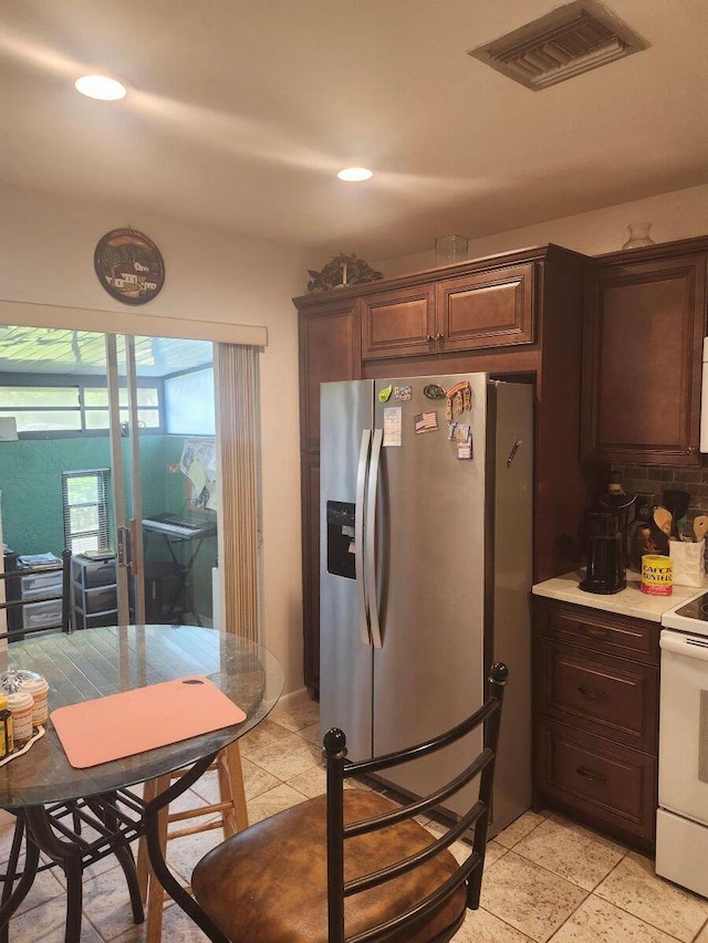5794 Moss Ct Unit 7, Fort Pierce, FL 34982 - kitchen featuring white range with electric cooktop, stainless steel refrigerator with ice dispenser, light countertops, dark brown cabinets, and recessed lighting