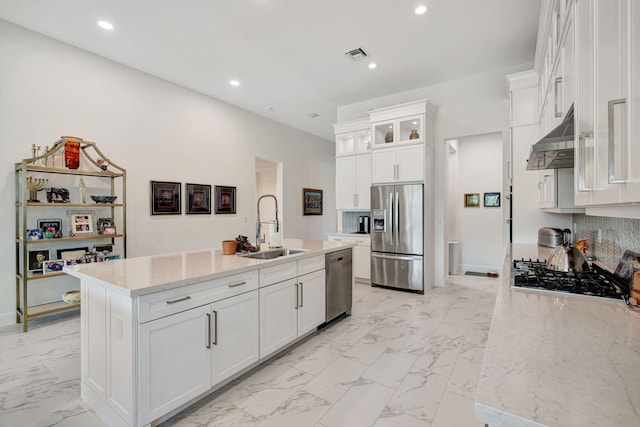 kitchen with appliances with stainless steel finishes, a sink, under cabinet range hood, light marble finish flooring, and recessed lighting