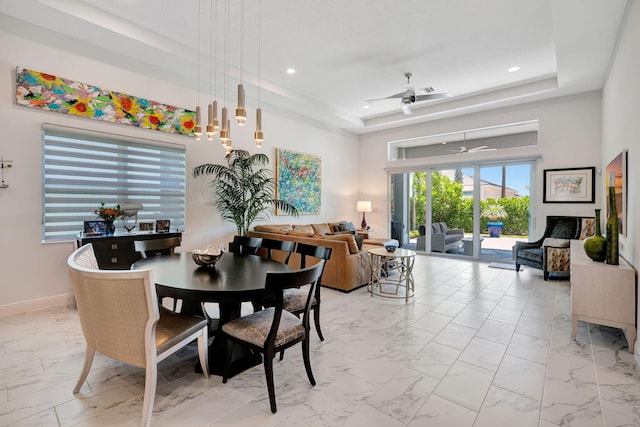 dining room featuring light marble finish floors, ceiling fan, a tray ceiling, recessed lighting, and baseboards