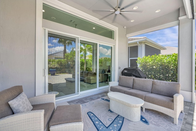 sunroom featuring a ceiling fan and an outdoor living space