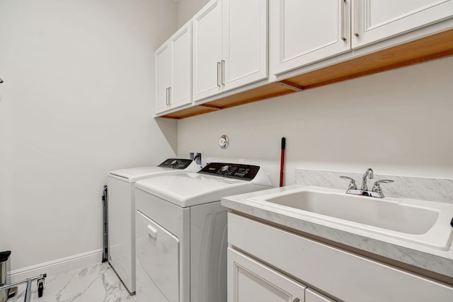 laundry area with washer and dryer, cabinet space, light marble finish flooring, and baseboards