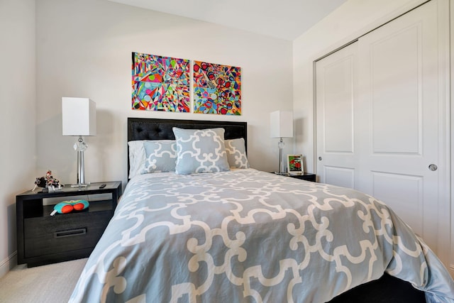 carpeted bedroom with a closet and baseboards