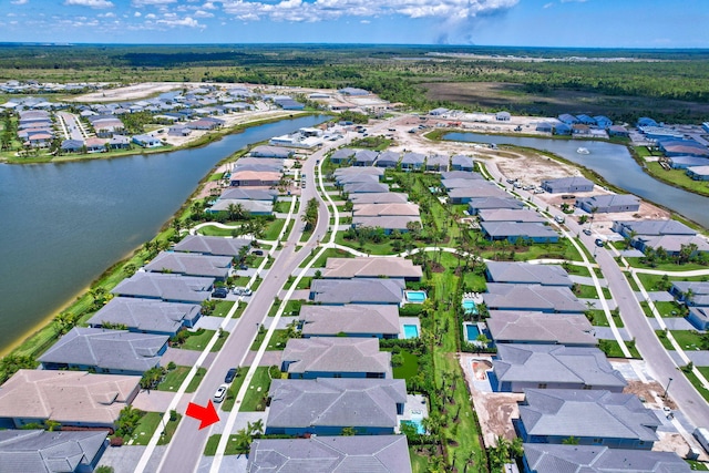 aerial view of property and surrounding area with nearby suburban area and a large body of water