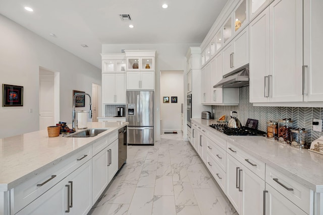kitchen featuring stainless steel appliances, under cabinet range hood, a sink, light marble finish flooring, and recessed lighting