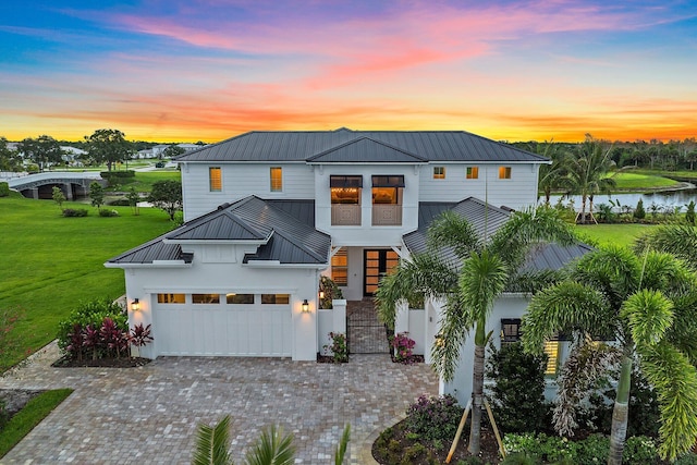 20049 SE Bridgewater Dr, Jupiter, FL 33458 - view of front of property featuring metal roof, a standing seam roof, a front yard, decorative driveway, and a water view