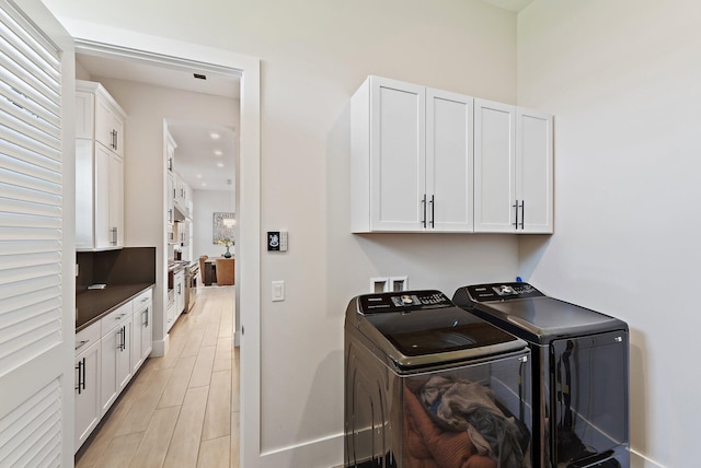 20049 SE Bridgewater Dr, Jupiter, FL 33458 - laundry room with separate washer and dryer, cabinet space, baseboards, and light wood-style flooring