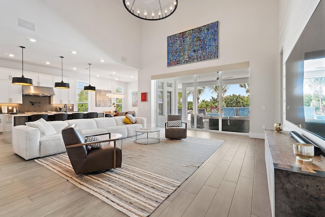 20049 SE Bridgewater Dr, Jupiter, FL 33458 - living area with light wood-type flooring, a chandelier, healthy amount of natural light, a high ceiling, and recessed lighting