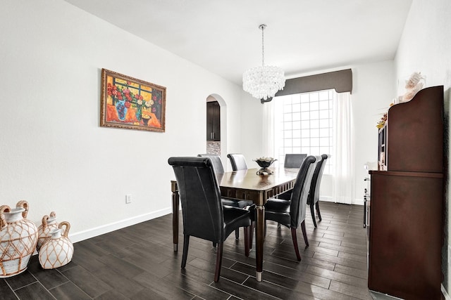 dining area with arched walkways, a chandelier, baseboards, and dark wood-style floors