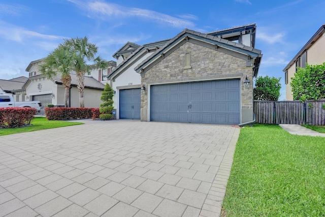 view of front of home with stone siding, an attached garage, decorative driveway, and a tiled roof