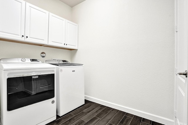 laundry room with cabinet space, separate washer and dryer, baseboards, and wood finish floors