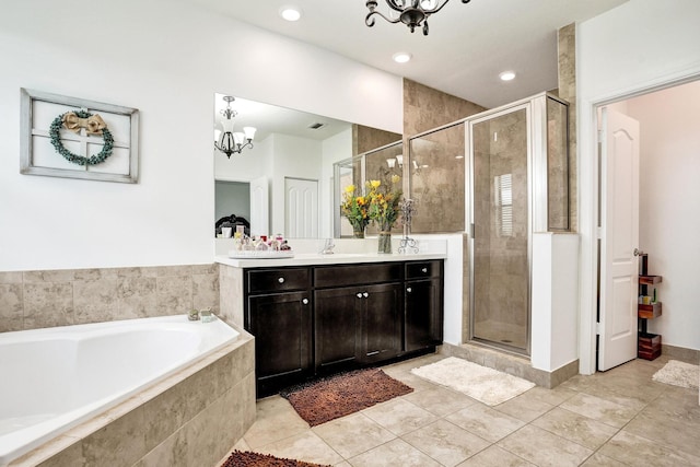 full bath with a chandelier, a shower stall, vanity, a bath, and tile patterned flooring