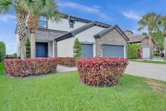 view of front facade featuring stone siding, stucco siding, a garage, a front yard, and driveway