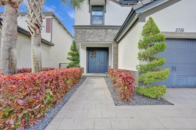 view of exterior entry featuring stucco siding and stone siding