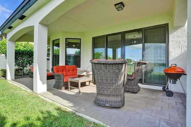 view of patio with an outdoor living space and a grill