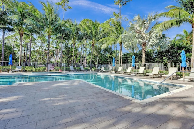 community pool with fence and a patio
