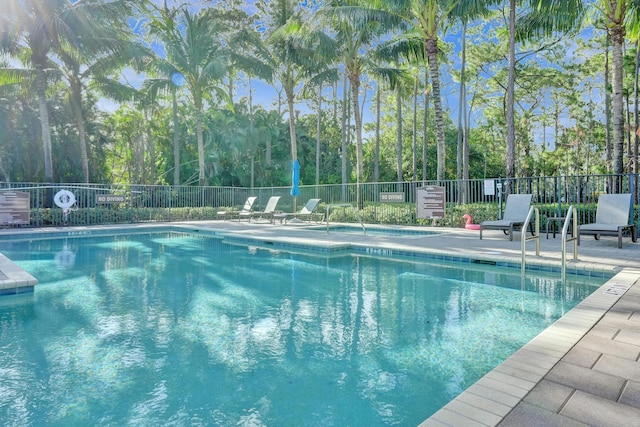 community pool with fence and a patio area