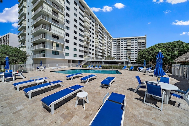 community pool featuring fence and a patio