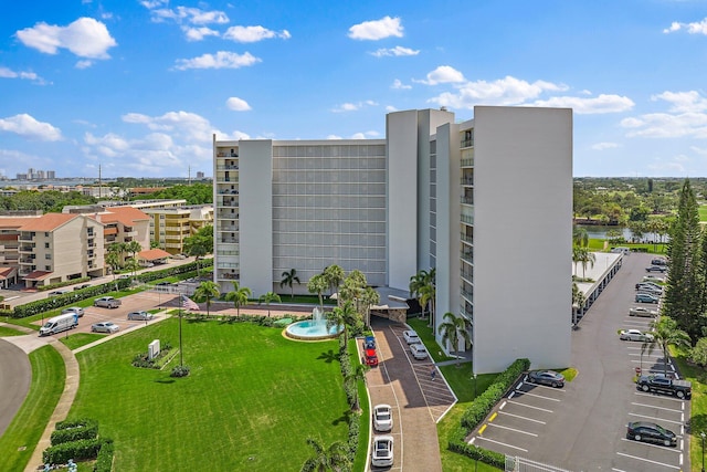 view of property featuring uncovered parking and a cooling unit