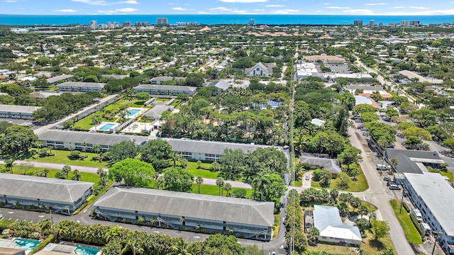 aerial view of property and surrounding area featuring a nearby body of water and nearby urban area
