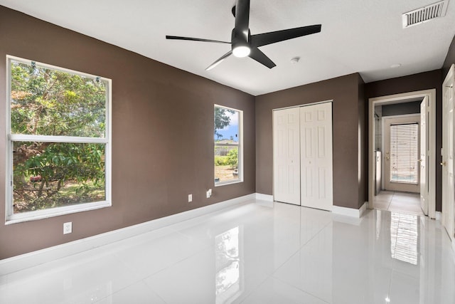 632 SW Mccall Rd, Port Saint Lucie, FL 34953 - unfurnished bedroom with light tile patterned flooring, a closet, a ceiling fan, and baseboards