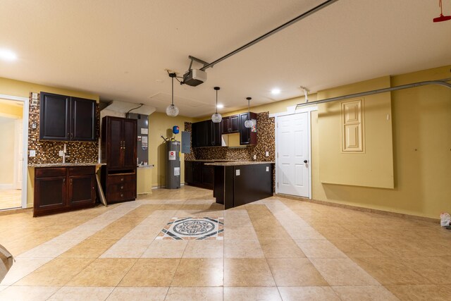 2853 SE Melaleuca Blvd, Port Saint Lucie, FL 34952 - kitchen featuring water heater, backsplash, light tile patterned flooring, recessed lighting, and light countertops